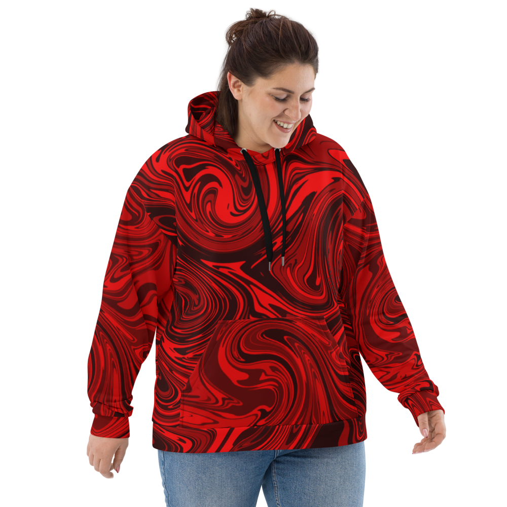 A woman wearing a plus-size red and black abstract swirl patterned hoodie with black drawstrings. The hoodie has a relaxed fit and features bold, fluid lines in an artistic, modern design. She is smiling and looking down, showcasing the front of the hoodie against a neutral background.